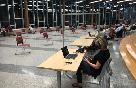 A picture of a board meeting during Covid-19 pandemic, chairs are separated by 6 feet and board members are separated by 6 feet. Attendance is very sparse.