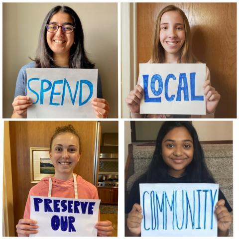 A picture of four students on Zoom holding signs that say spend local, preserve our community.