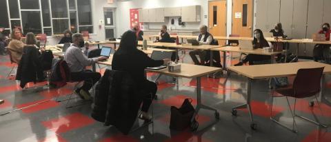 A school board meeting that is spaced out in a large meeting space due to Covid-19.