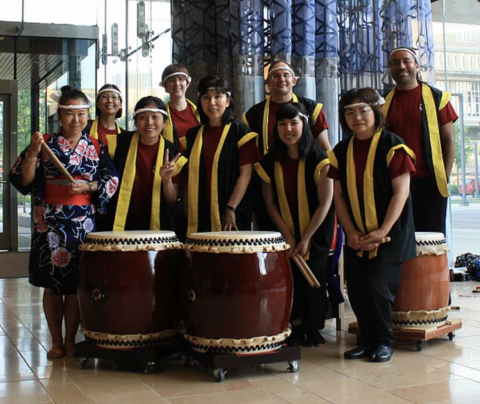 A picture of the Japenese Taiko Group are pictured in their ceremonial wear with their musical instruments.