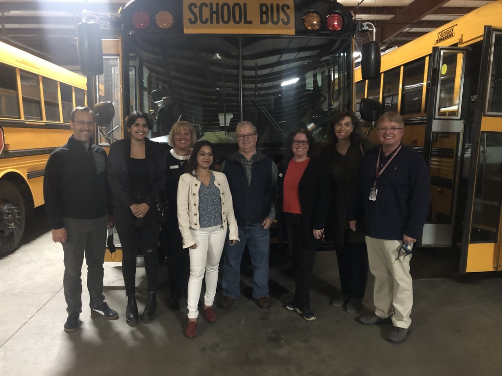 Board of Education Standing in front of a school bus