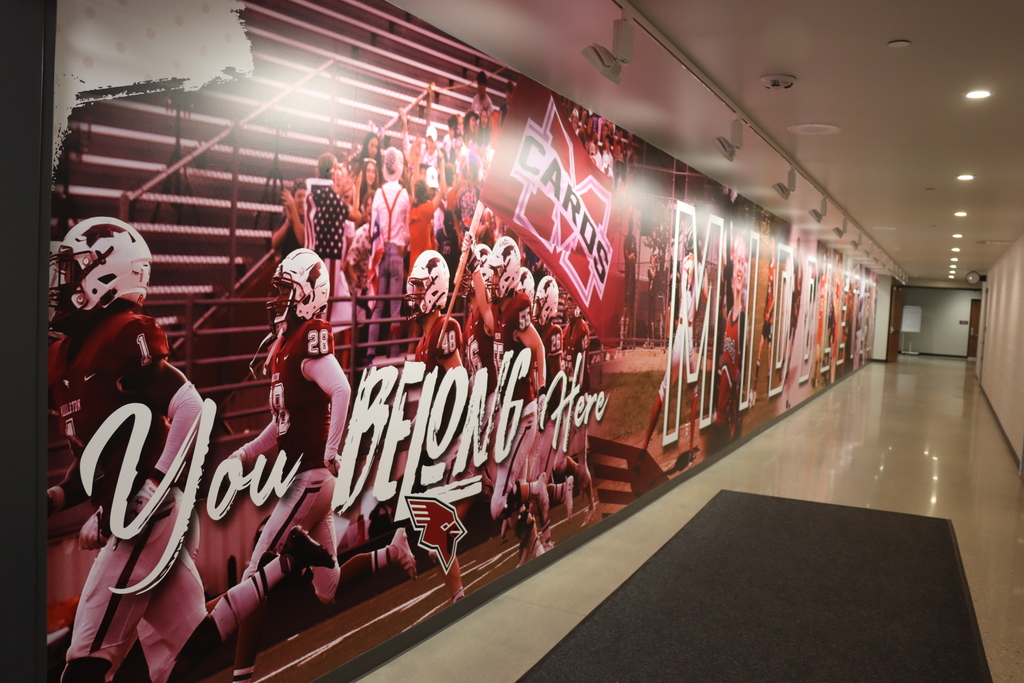Hallway mural of football plays in action with the words on the bottom lefthand side that say "you belong here"